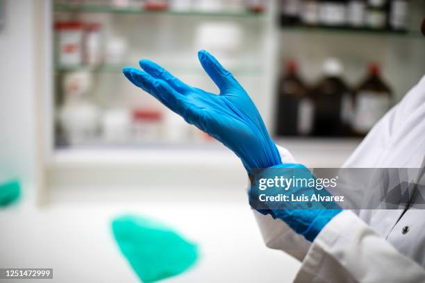 chemist wearing protective hand gloves - plastic glove stock pictures, royalty-free photos & images