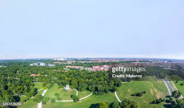 aerial view of the english garden or englischer garten in munich and the munich skyline - englischer garten stock-fotos und bilder