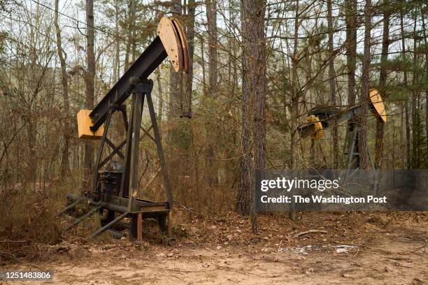 Pump jack sits on the side of a path where its well was orphaned and capped near Oil City, Louisiana on March 8, 2023.