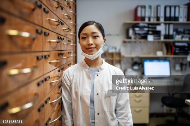 woman working at pharmacy store - japanese workers stock-fotos und bilder
