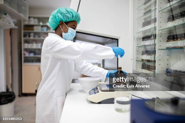 female chemist preparing medicine in pharmacy laboratory - pharmacy mask stock pictures, royalty-free photos & images