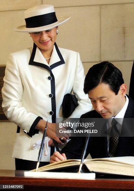 Japanese crown prince Naruhito, signs the guest book as his wife crown princess Masako watches at the Australian war memorial in Canberra, 18...