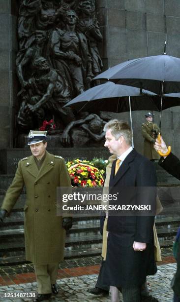 Belgium's Prince Philippe with his wife Princess Mathilde leave the ghetto monument in Warsaw, 19 November 2003 after laying a wreath on the third...