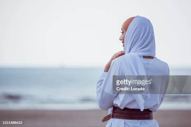 beautiful muslim woman wearing hijab in the summer - muslim woman beach stock pictures, royalty-free photos & images