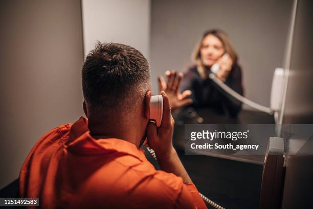 young woman and her husband sitting in prison visiting room - prison imagens e fotografias de stock