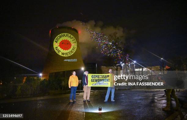 Activists of the nationwide anti-nuclear organisation 'ausgestrahlt' pose with a placard reading 'Won together' while a cooling tower of the nuclear...