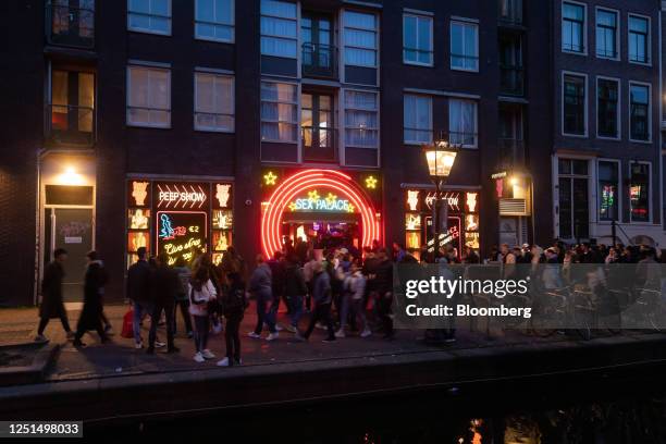 Tourists along the Oudezijds Achterburgwal canal in the red light district in Amsterdam, Netherlands, on Sunday, April 9, 2023. Amsterdam is...