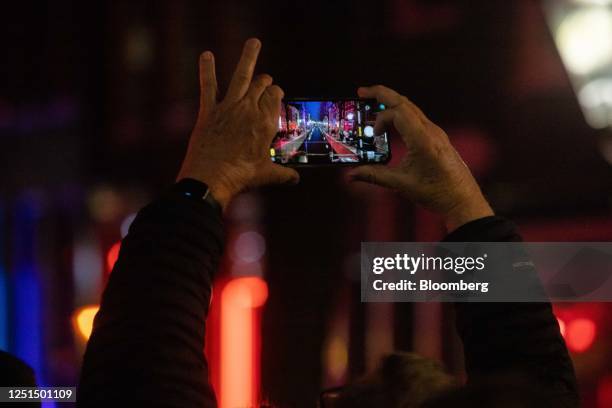 Tourist takes a photograph of the Oudezijds Achterburgwal canal in the red light district in Amsterdam, Netherlands, on Sunday, April 9, 2023....