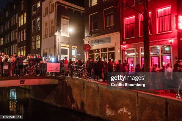 Tourists along the Oudezijds Achterburgwal canal in the red light district in Amsterdam, Netherlands, on Sunday, April 9, 2023. Amsterdam is...