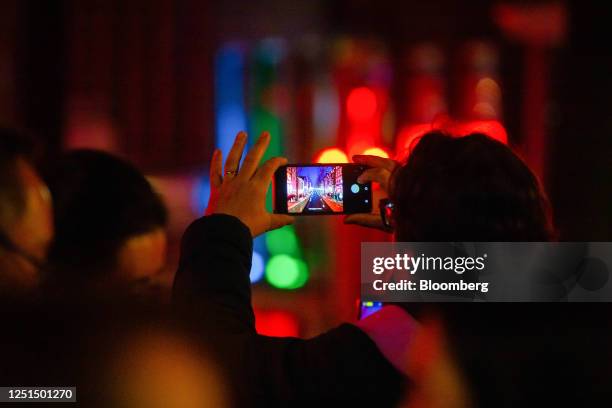Tourist takes a photograph of the Oudezijds Achterburgwal canal in the red light district in Amsterdam, Netherlands, on Sunday, April 9, 2023....