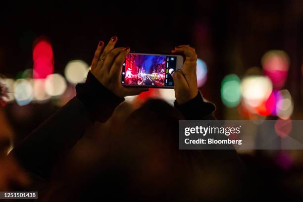 Tourist takes a photograph of the Oudezijds Achterburgwal canal in the red light district in Amsterdam, Netherlands, on Sunday, April 9, 2023....