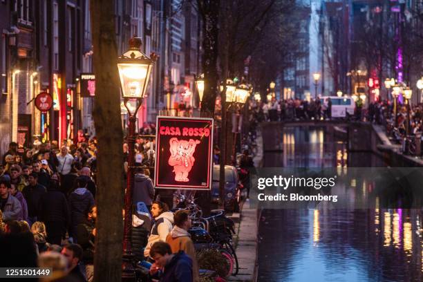 Tourists along the Oudezijds Achterburgwal canal in the red light district in Amsterdam, Netherlands, on Sunday, April 9, 2023. Amsterdam is...