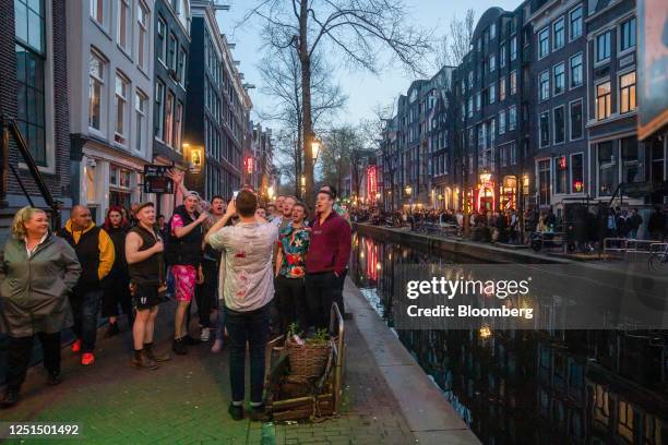 Tourists along the Oudezijds Achterburgwal canal in the red light district in Amsterdam, Netherlands, on Sunday, April 9, 2023. Amsterdam is...