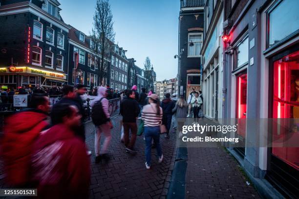 Tourists along the Oudezijds Achterburgwal canal in the red light district in Amsterdam, Netherlands, on Sunday, April 9, 2023. Amsterdam is...