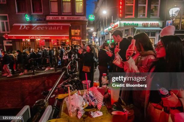 Tourists along the Oudezijds Achterburgwal canal in the red light district in Amsterdam, Netherlands, on Sunday, April 9, 2023. Amsterdam is...