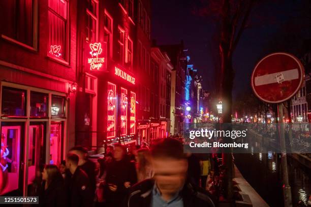 Tourists along the Oudezijds Achterburgwal canal in the red light district in Amsterdam, Netherlands, on Sunday, April 9, 2023. Amsterdam is...