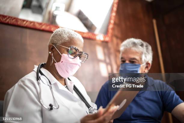 läkare talar med äldre manlig patient i ett hembesök - health technology bildbanksfoton och bilder