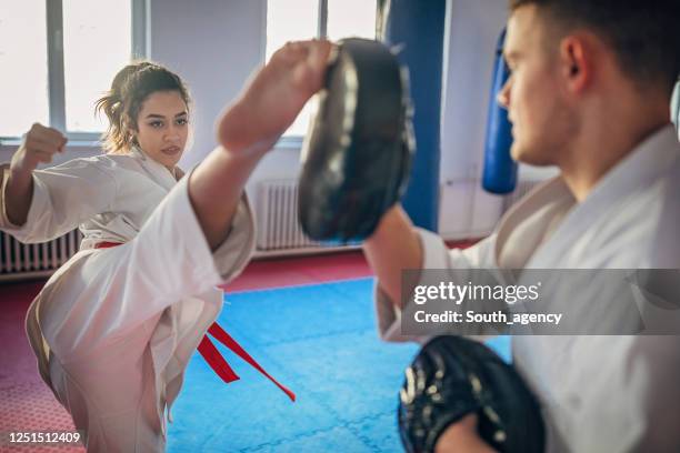 karatestudentsparring mit ihrem trainer drinnen - karateka stock-fotos und bilder