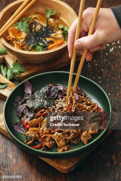 homem adulto comendo comida japonesa tradicional - soba - fotografias e filmes do acervo