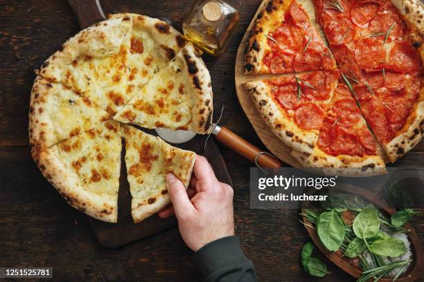 hombre adulto comiendo pizza italiana pepperoni y pizza de cuatro quesos - pizza de chorizo fotografías e imágenes de stock
