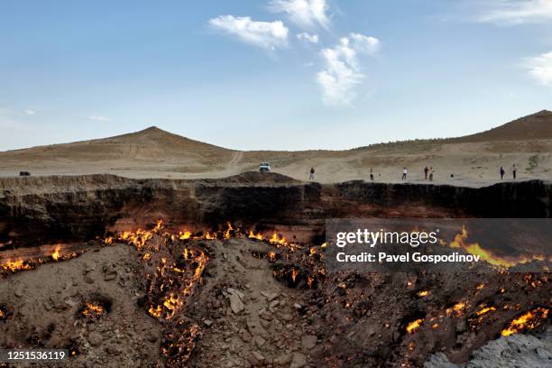 tourists visiting the burning darvaza gas crater at sunset, turkmenistan - cratera vulcânica imagens e fotografias de stock
