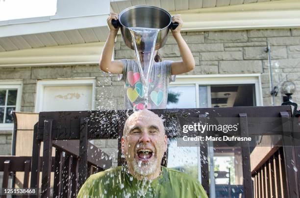 女孩把水滴在父親的頭上 - heatwave 個照片及圖片檔