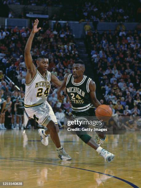Shawn Respert, Guard for the Michigan State Spartans drives on past Jimmy King, Guard for the University of Michigan Wolverines during their NCAA...