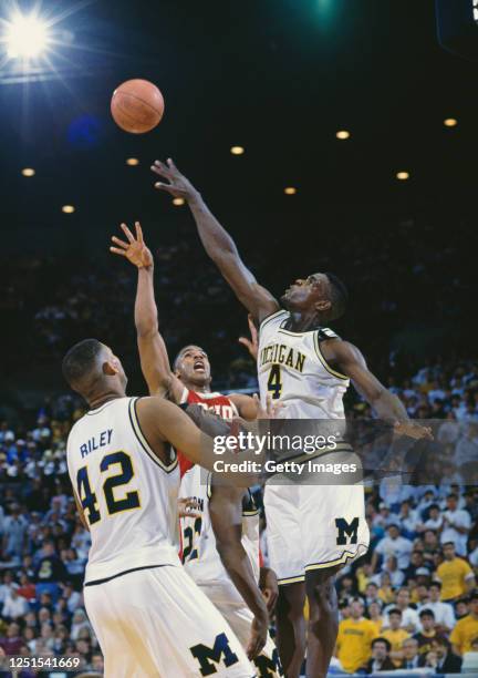 Chris Webber, Forward for the University of Michigan Wolverines and Jim Jackson, Guard for the Ohio State Buckeyes contest the ball over Eric Riley...