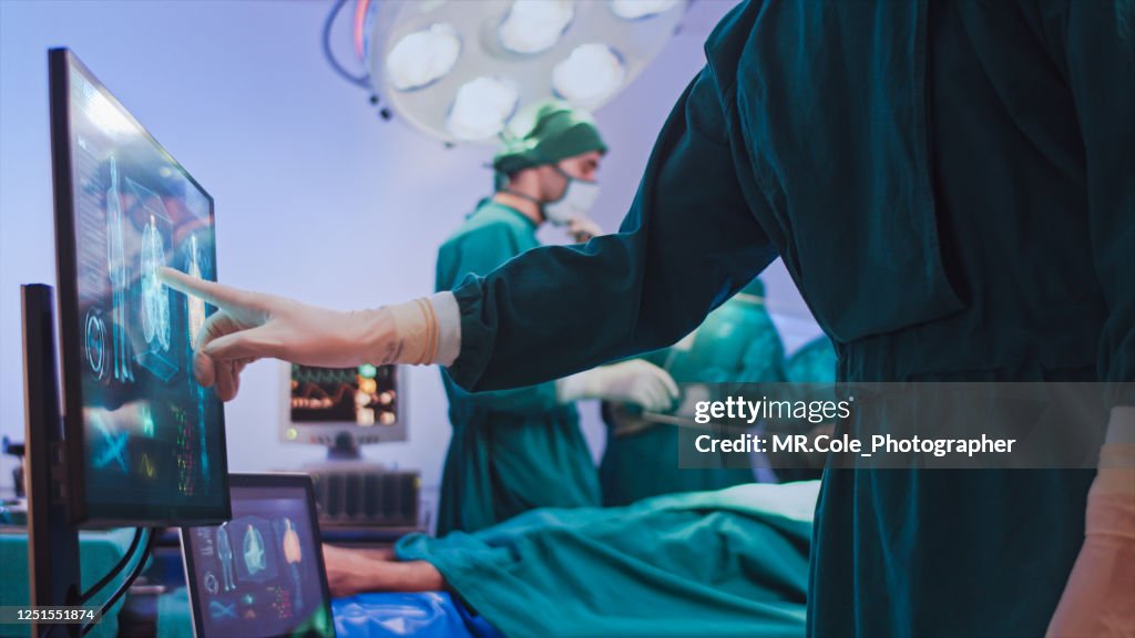 Doctor using hologram modern virtual screen interface in the operating room, innovative and future of medical and healthcare technology