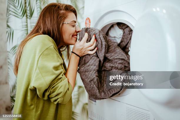 jonge vrouw die haar was thuis doet - laundry stockfoto's en -beelden