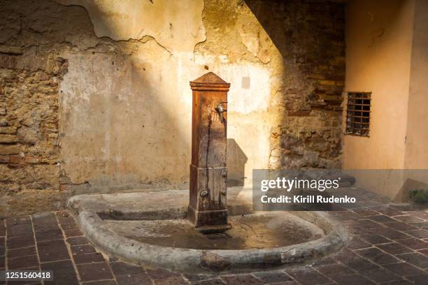 an old water well in a small italian town - drinkwaterfontein stockfoto's en -beelden