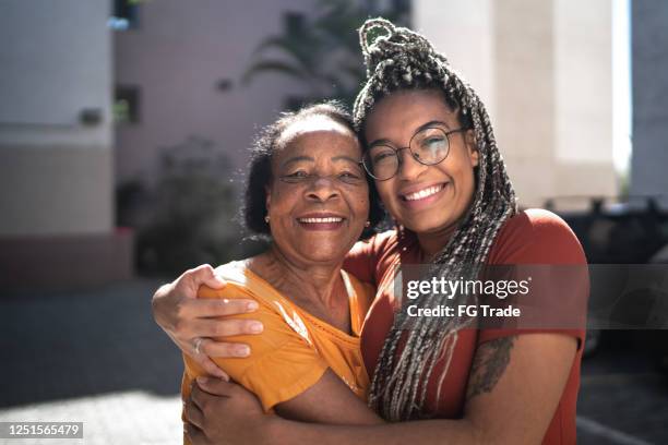 porträt von großmutter und enkelin, die sich draußen umarmen - brazilian woman stock-fotos und bilder