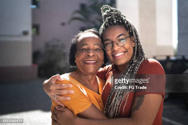 portrait of grandmother and granddaughter embracing outside - granddaughter stock pictures, royalty-free photos & images
