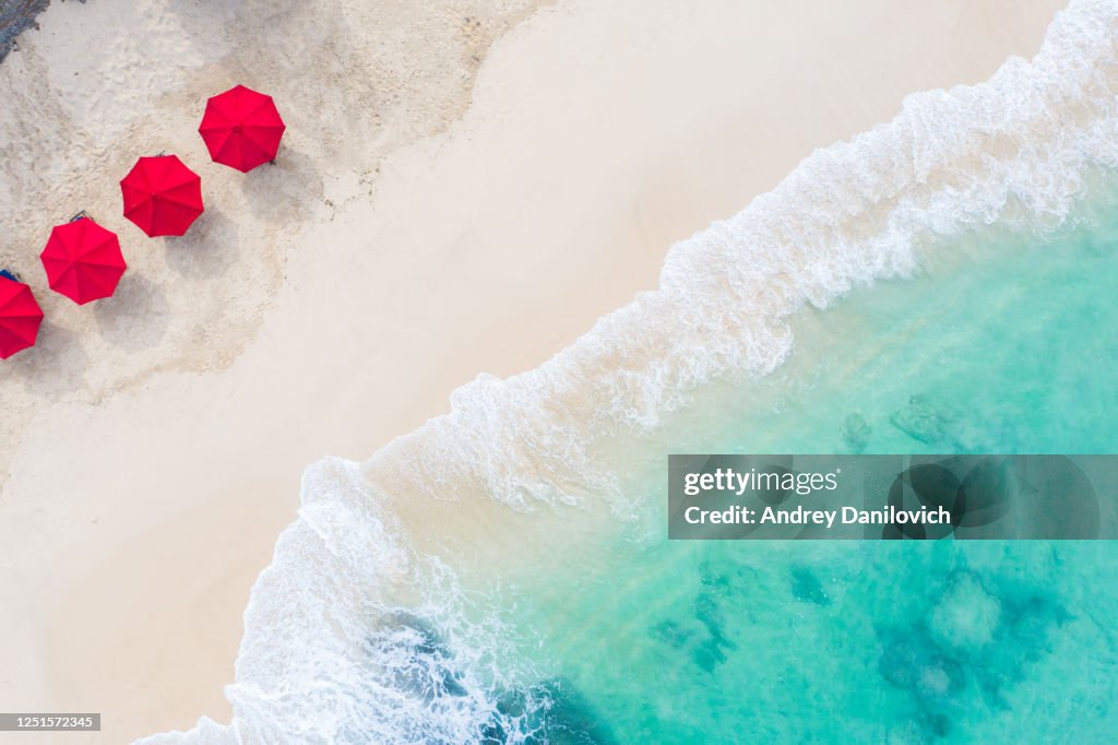 Beach umbrellas and blue ocean. Beach scene from above