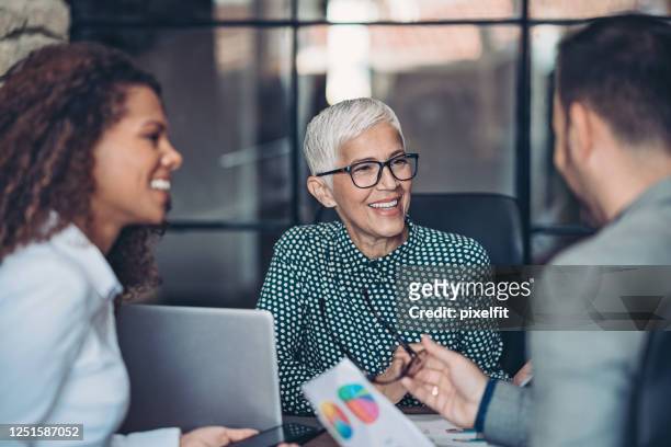 senior businesswoman with to her younger team - role model stock pictures, royalty-free photos & images