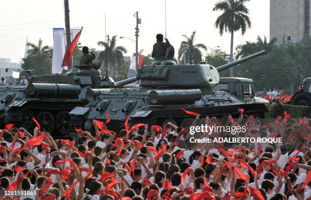 Cuban pioneers wave their kerchiefs simulating waves, on April 16 around the vintage URSS-made T-34/85 tank and the SU-100 self-propelled-gun used by...