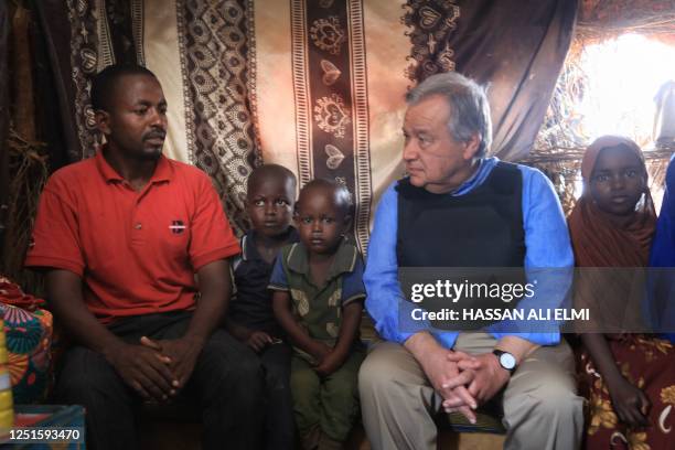 Secretary general Antonio Guterres sits with a displaced family as he visits an Internal Displaced Persons camp in Baidoa on April 11, 2023 -...