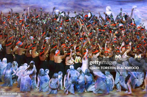 Performers crowd the grounds of the Olympic Stadium during the "Djakapurra & clans & Wandjina" segment of the opening ceremony of the 2000 Summer...
