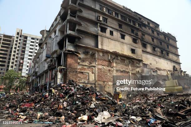 April 09 Dhaka, Bangladesh: people help to lift the rubble of the past fire from the ashes of Banga Bazar, where several people were seriously...