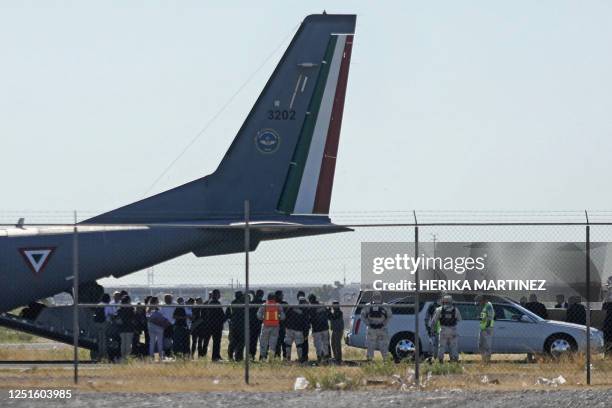 The bodies of 23 migrants who died on March 27 during a fire at the National Migration Institute are loaded into a plane of the Mexican Air Force for...