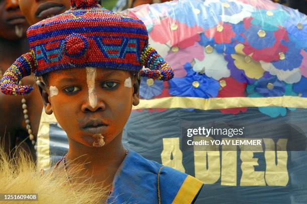 Democratic Republic of Congo child, dressed in traditional clothes and standing next to a wreath displaying "Good Bye", attends 23 January 2001 the...