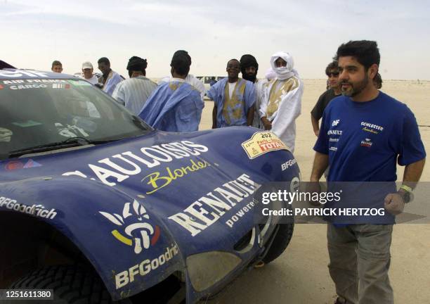 Spanish driver Jose-Maria Servia jubilates as he stands by his Megane-Schlesser 12 January 2001 after he carried off the 11th leg in Nouakchott,...