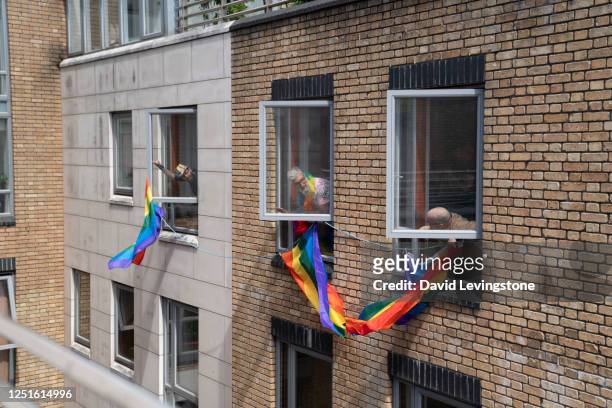neighbours sharing gay pride flags in support of lgbtqi+ pride parade at home. - dublin city skyline stockfoto's en -beelden