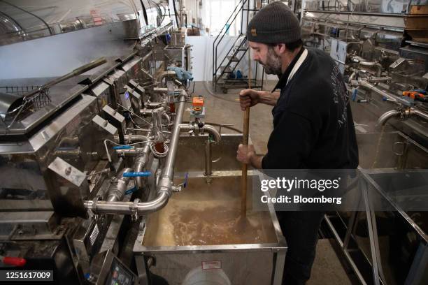 Worker agitates freshly cooked maple syrup to bring it to the right thickness at a sugar shack near Lac Brome, Quebec, Canada, on Monday, April 10,...