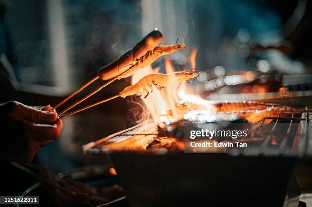 a night bbq party gathering with food preparation with prawn and hotdog skewer - hand chicken wing stock pictures, royalty-free photos & images