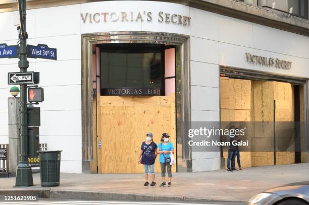 People wear protective face masks outside Victoria's Secret in midtown as the city moves into Phase 2 of re-opening following restrictions imposed to...