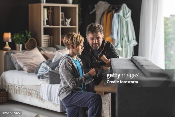 father and son building together a sofa during times of social distancing - lockdown drill stock pictures, royalty-free photos & images