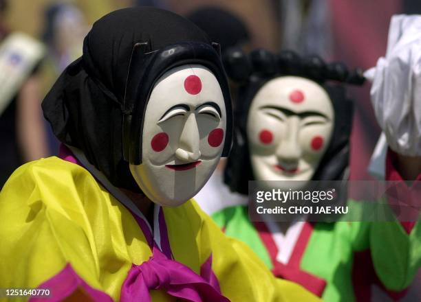 Two South Korean women wearing traditional costume perform during the preview of the Andong mask festival in Seoul, 08 September 2002. The festival...