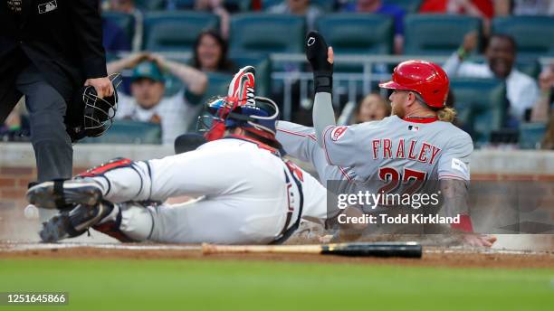 Jake Fraley of the Cincinnati Reds scores against Sean Murphy of the Atlanta Braves in the third inning at Truist Park on April 11, 2023 in Atlanta,...