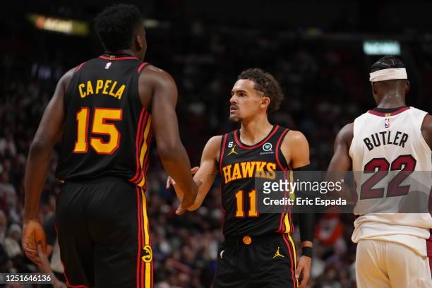 Trae Young of the Atlanta Hawks high-fives teammate Clint Capela during the 2023 Play-In Tournament against the Miami Heat on April 11, 2023 at...